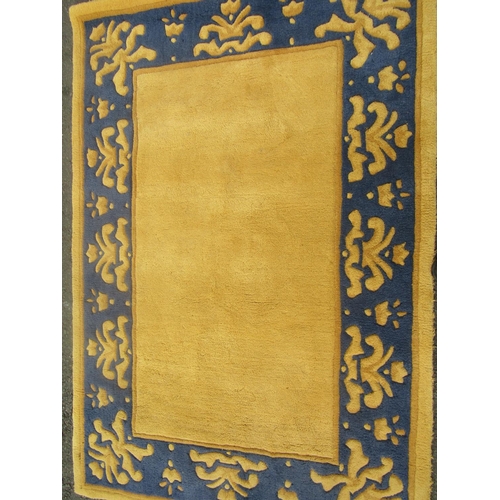 1813 - A thick pile wool carpet with a yellow rectangular panel and a yellow and blue border, 180cm c 120cm... 