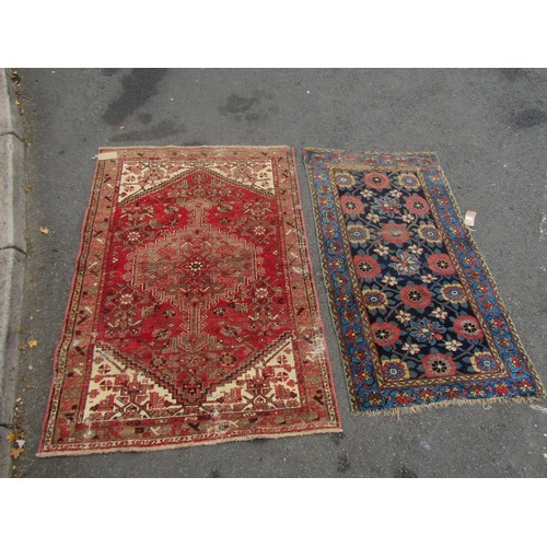 1824 - An antique worn and torn Persian rug with a floral pattern 175cm x 95cm and another old Middle Easte... 