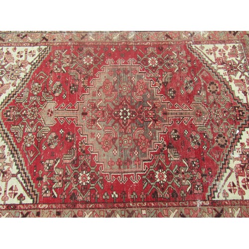 1824 - An antique worn and torn Persian rug with a floral pattern 175cm x 95cm and another old Middle Easte... 