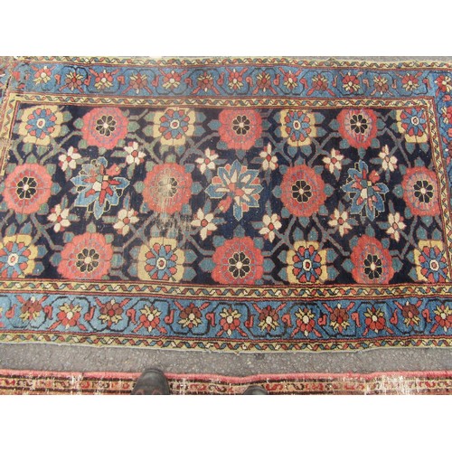 1824 - An antique worn and torn Persian rug with a floral pattern 175cm x 95cm and another old Middle Easte... 