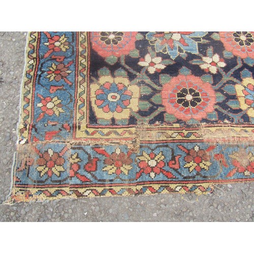 1824 - An antique worn and torn Persian rug with a floral pattern 175cm x 95cm and another old Middle Easte... 