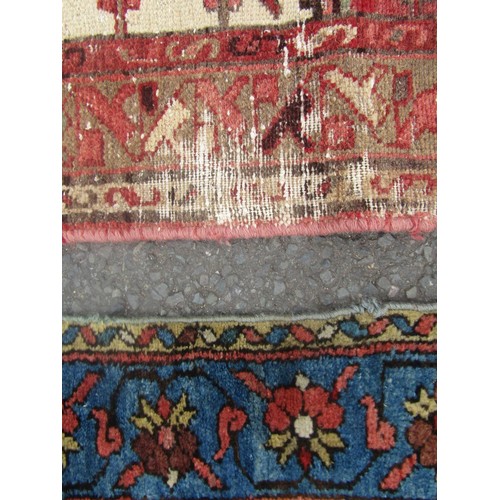 1824 - An antique worn and torn Persian rug with a floral pattern 175cm x 95cm and another old Middle Easte... 