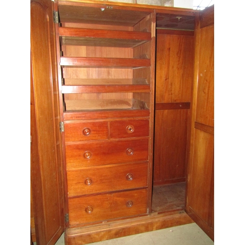 1395 - A Victorian satin birch wardrobe enclosed by three arched panelled doors, the central with mirror pl... 