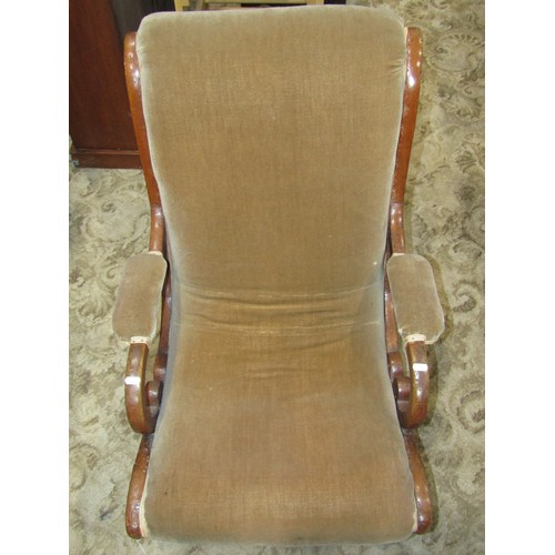 1189 - A Victorian  mahogany nursing chair with scrolled outline, open arms and upholstered seat