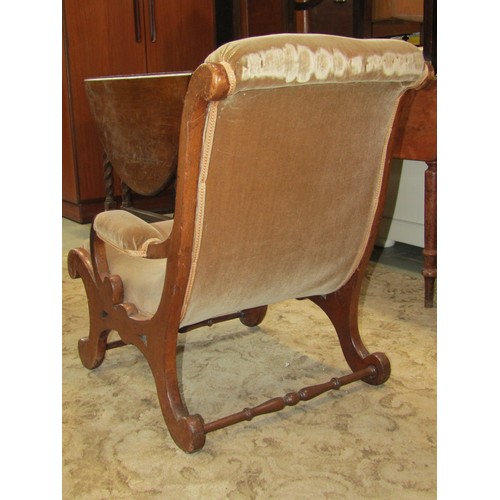 1189 - A Victorian  mahogany nursing chair with scrolled outline, open arms and upholstered seat