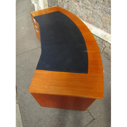 1191 - A 1970s teak office desk with unusual curved top incorporating a writing surface set on twin pedesta... 