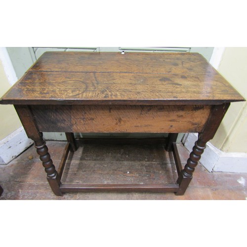 1559 - An antique oak side table enclosing two frieze drawers, raised on turned bobbin supports, 78cm wide