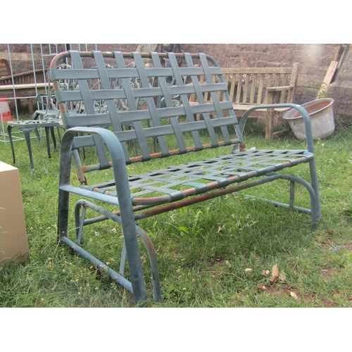 2009 - A green painted tubular steel framed two seat rocking garden bench with interlaced strapwork seat an... 