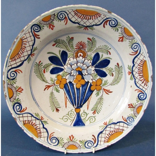 1042 - A late 18th century tin glazed charger with hand painted floral detail, 35cm diameter