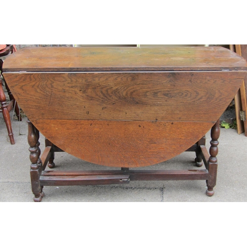 2319 - A Georgian oval drop leaf gateleg dining table, principally in oak, raised on six turned supports un... 