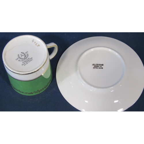 1055a - A set of twelve Allerton coffee cans and saucers with green ground with floral bouquet detail