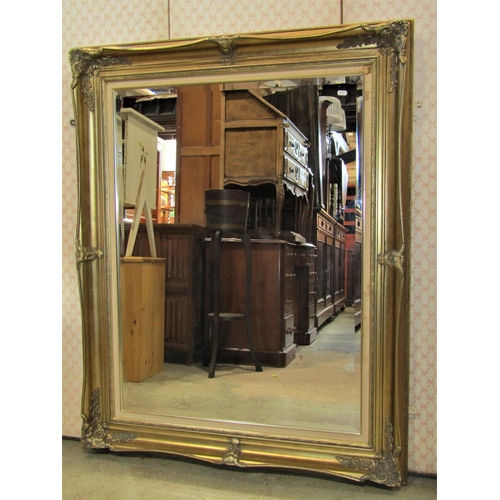 2469 - A large contemporary antique style wall mirror with bevelled edge plate within a swept and moulded g... 