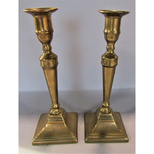 1657 - A pair of Georgian brass candlesticks, classical column design on a square base, 25cm high.