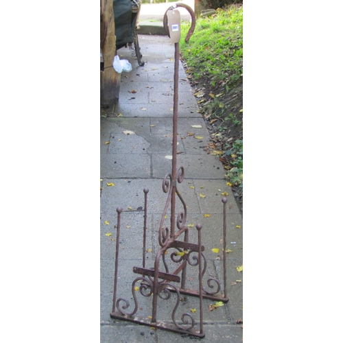 2001 - A weathered ironwork boot stand with S scroll detail and removable loop handle, 125 cm high