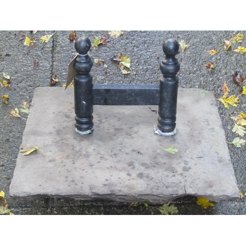 2007 - A cast iron boot scraper set in a square weathered stone paving slab, 46 cm square approximately