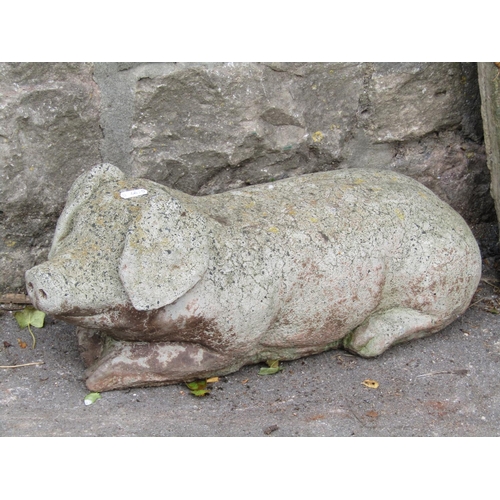 2011 - A weathered cast composition stone garden ornament in the form of a recumbent pig together with two ... 