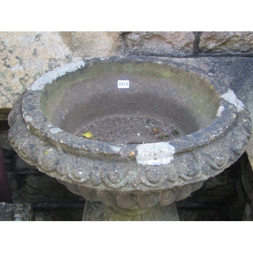 2012 - A weathered cast composition stone garden urn, the shallow circular lobed bowl with flared egg and d... 