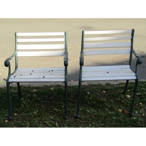 2031 - A pair of garden open armchairs with painted wooden slatted seats and cast iron supports, 60 cm wide... 