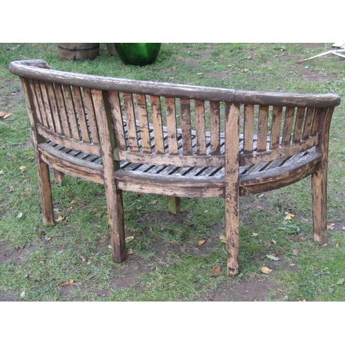 2043 - A stained hardwood banana shaped garden bench 160 cm wide