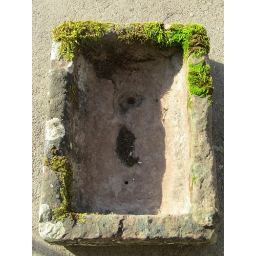 2081 - A weathered natural stone trough of rectangular form, 64cm long x 45cm wide x 18cm deep