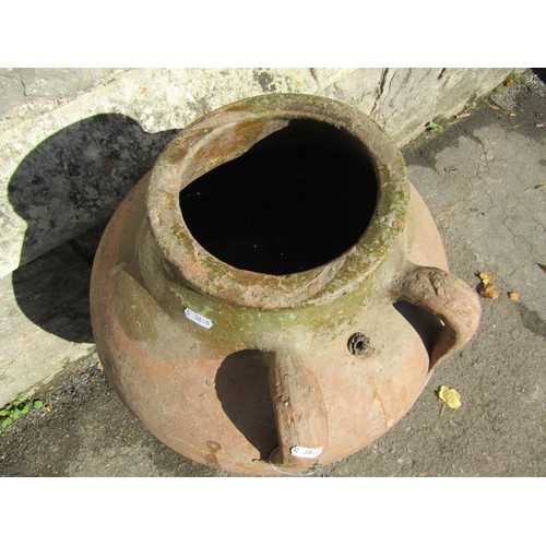 2083 - An old terracotta tapered oviform jar with three moulded loop handles and the remains of a partially... 