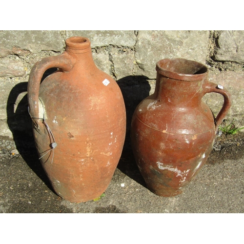 2096 - An old matt glazed terracotta jug with moulded loop handle and simple incised detail, 33cm high, tog... 