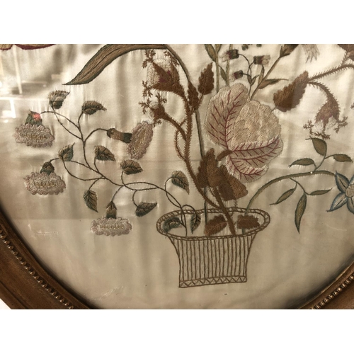 81 - Silk embroidery depicting a basket of flowers on cream silk satin (19th century or earlier) oval fra... 