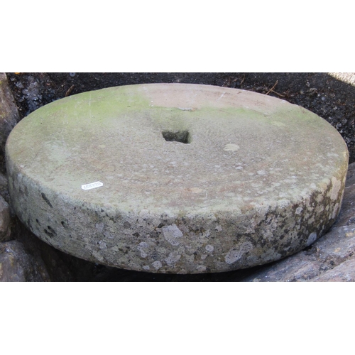 2113 - A weathered natural stone millstone, 46cm diameter x 8cm thick