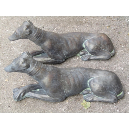 2141 - A matched pair of cast composition stone garden ornaments of recumbent whippets with simulated bronz... 