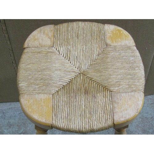 2245 - A set of four beechwood stools with rush seats raised on turned supports