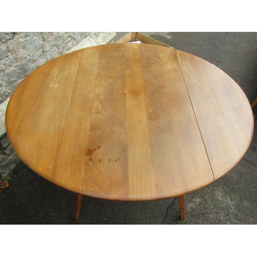 2254 - A vintage Ercol light elm oval drop leaf kitchen table raised on splayed square tapered supports to ... 