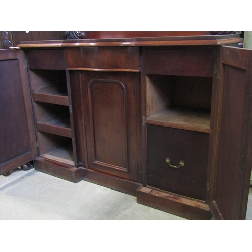 2271 - A Victorian mahogany chiffonier enclosed by three arched and moulded panelled doors flanking a centr... 