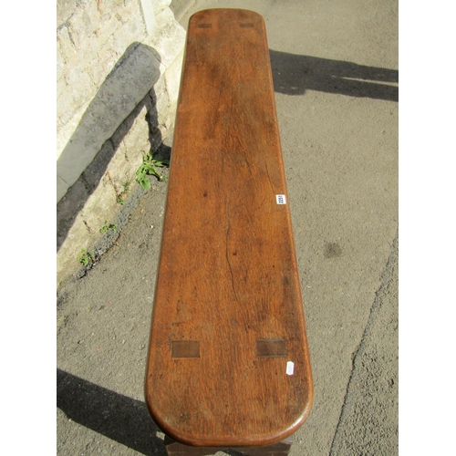 2251 - A 19th century oak bench with a plank seat and rounded ends raised on through jointed and shaped sup... 