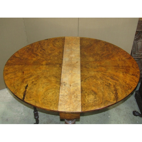 2301 - A Victorian figured and burr walnut veneered oval drop leaf Sutherland table on spiral supports and ... 