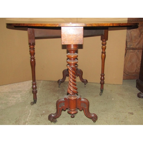 2301 - A Victorian figured and burr walnut veneered oval drop leaf Sutherland table on spiral supports and ... 