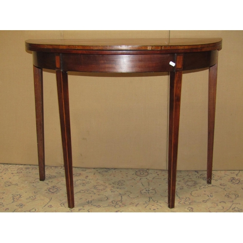 2302 - A Georgian mahogany demi-lune fold over top card table with crossbanded detail raised on square tape... 