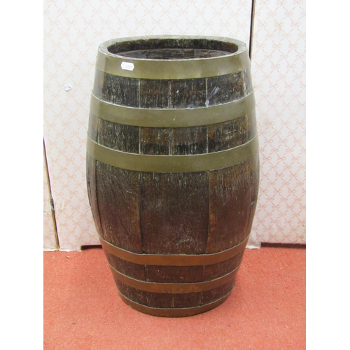 2635 - An antique oak barrel of oval form with coopered brass bands, 60cm high