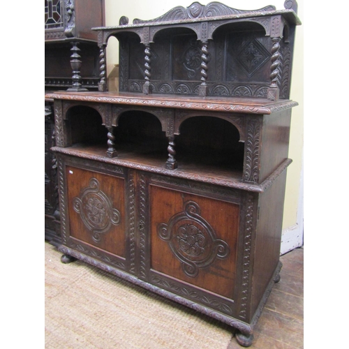 2640 - A Victorian gothic revival oak side cupboard, with panelled doors, open tiered shelves and geometric... 