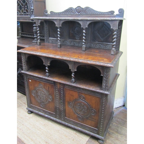 2640 - A Victorian gothic revival oak side cupboard, with panelled doors, open tiered shelves and geometric... 