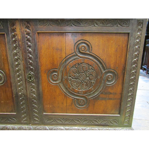 2640 - A Victorian gothic revival oak side cupboard, with panelled doors, open tiered shelves and geometric... 