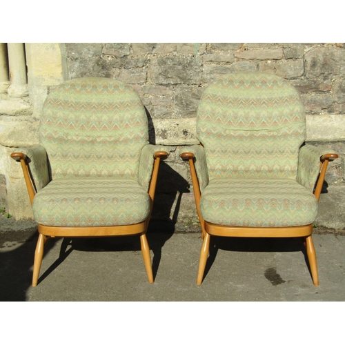 2645 - A light Ercol three seat stick-back sofa with two matching armchairs and a stool (4)