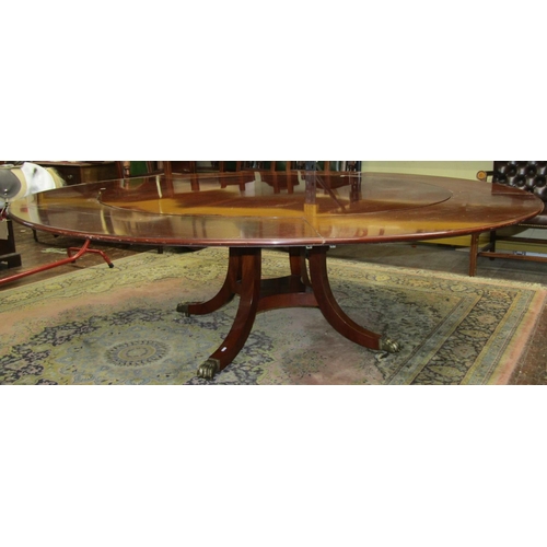 2656 - A good quality mahogany reproduction circular extending dining table, raised on swept supports with ... 