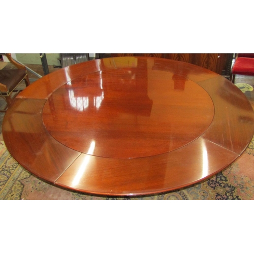 2656 - A good quality mahogany reproduction circular extending dining table, raised on swept supports with ... 