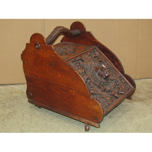 2366 - A Victorian gothic oak coal scuttle with carved handle and lid with lions mask, acorn and oak leaf d... 