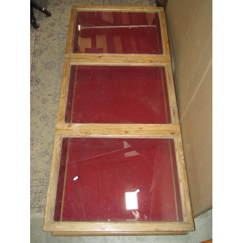 2413 - A vintage stripped pine counter top display case of rectangular form, enclosed by three glazed hinge... 