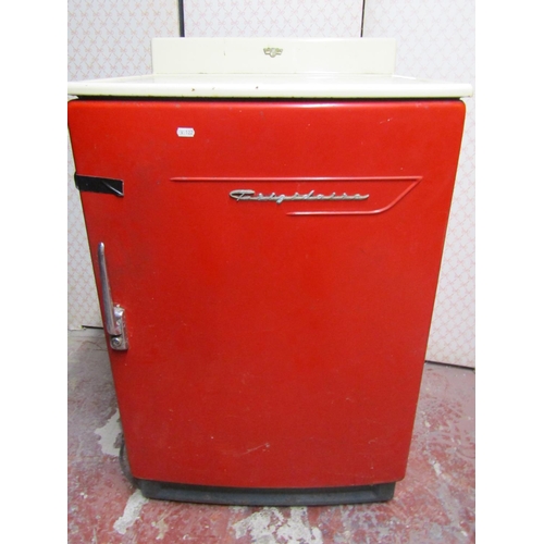 2564 - A vintage Frigidaire refrigerator, in red, with white enamel work surface