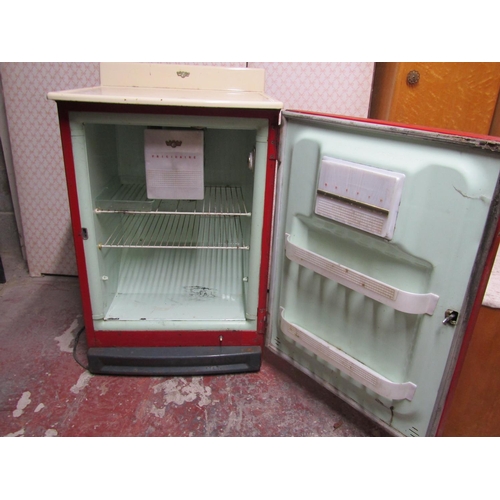 2564 - A vintage Frigidaire refrigerator, in red, with white enamel work surface