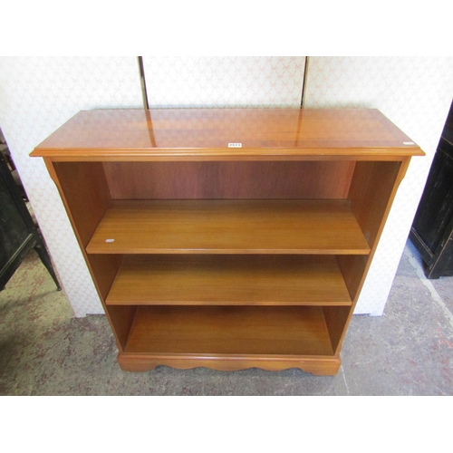 2571 - A reproduction yew wood veneered open bookcase fitted with two adjustable shelves on bracket support... 