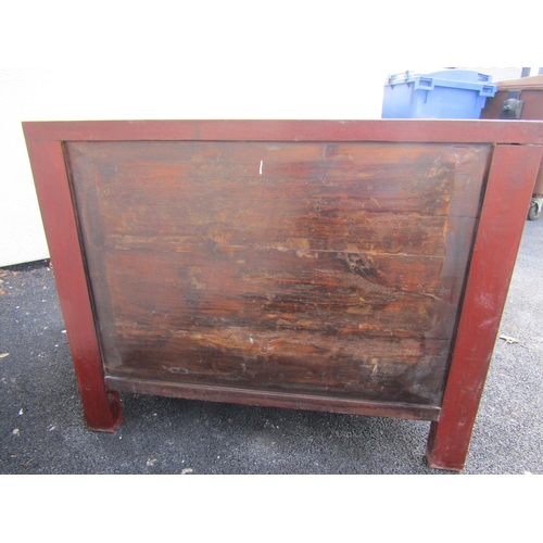 2576 - A Chinese red lacquered cabinet enclosed by cupboards and drawers with carved and painted detail wit... 