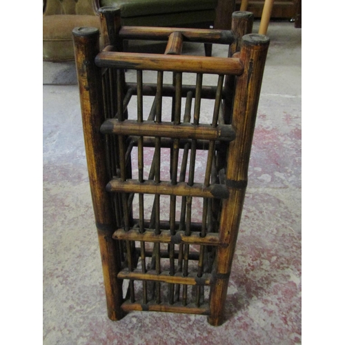 2585 - A Chinese wine rack to hold ten bottles and a red lacquered three tier container